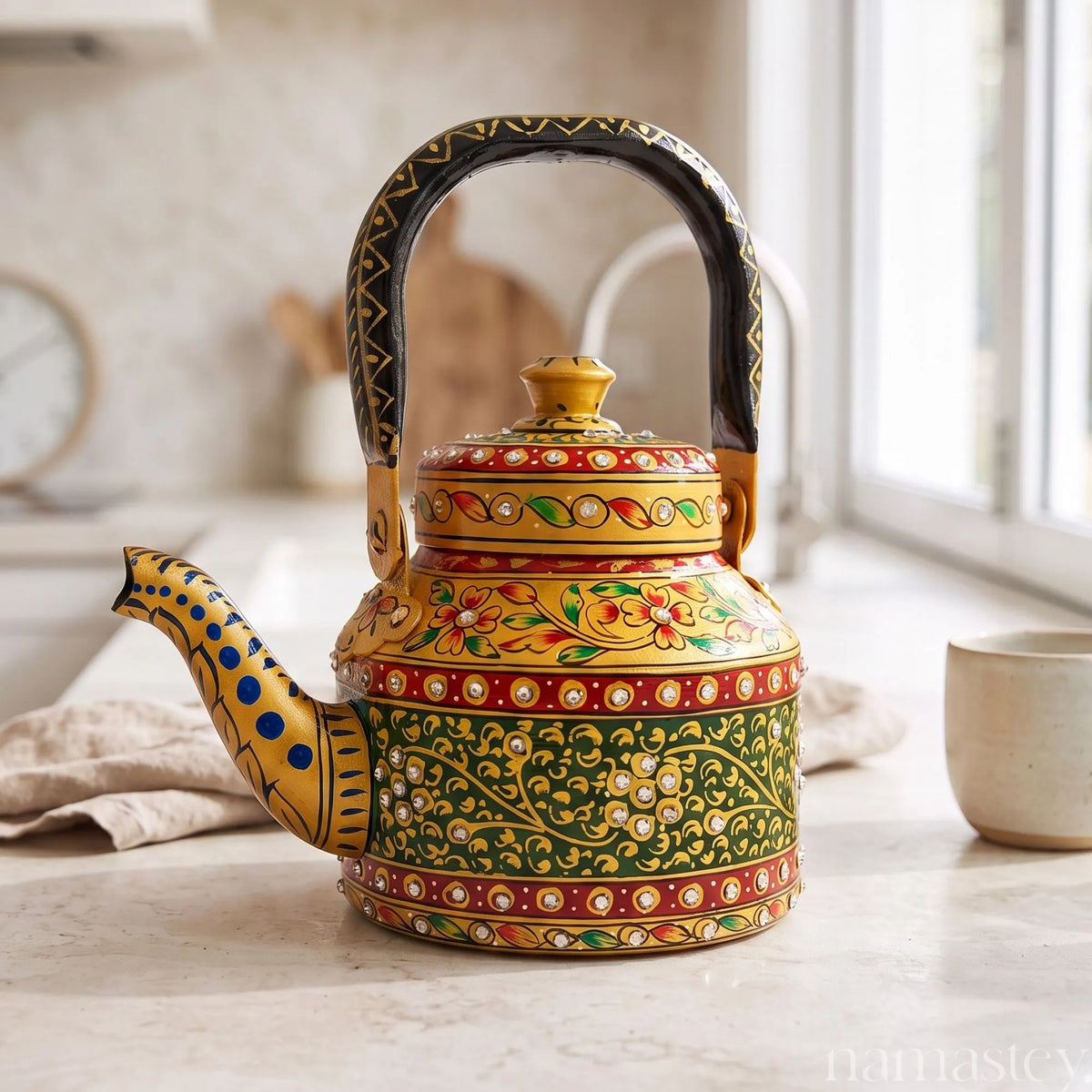 Handpainted Namastey stainless steel tea kettle on a stovetop