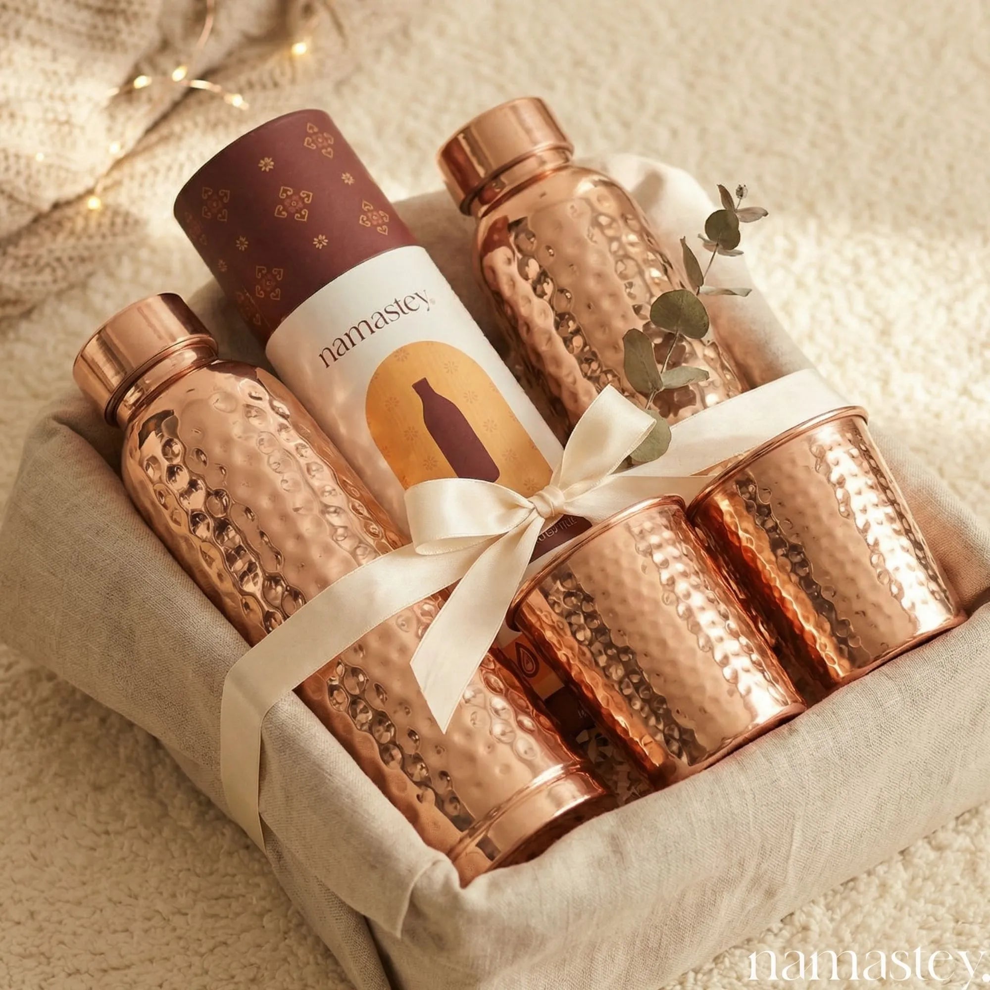 Morning Ritual copper gift set arranged in a linen gift basket with ribbon and eucalyptus