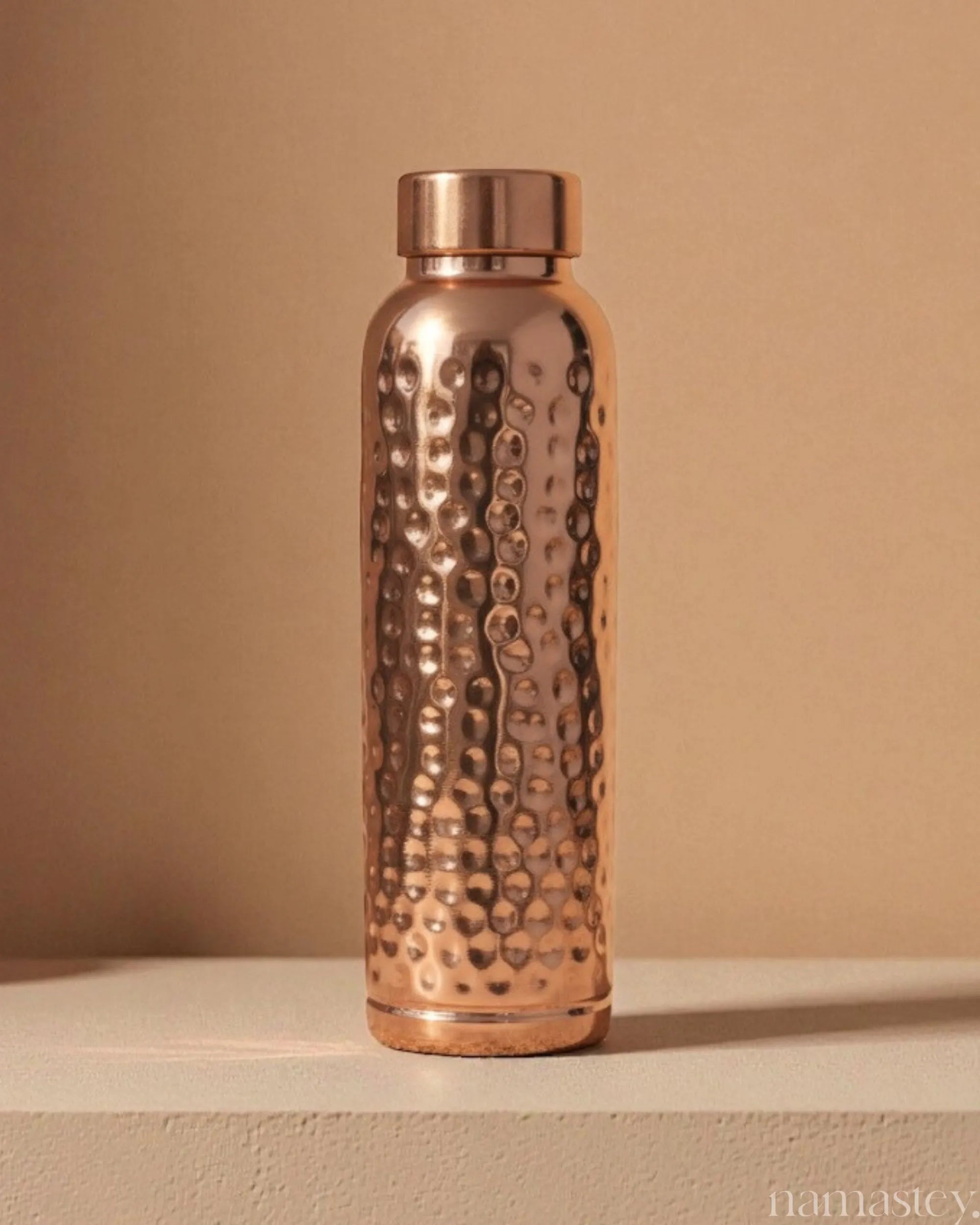 Classic hammered pure copper water bottle, 950ml, studio shot on a plinth
